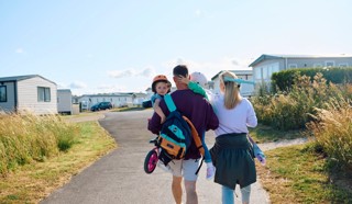 a family with children being carried through a caravan park with bikes