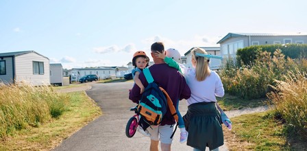 a family with children being carried through a caravan park with bikes