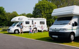 A family walks past their campervan at Kiln Park, South Wales.