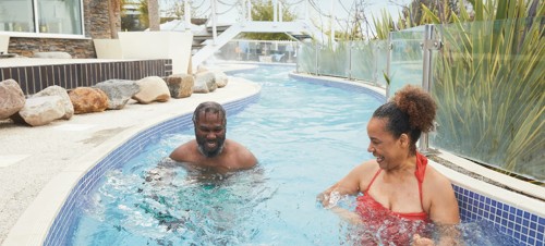 A couple enjoying swimming in the Lazy River at Haven Weymouth Bay, Dorset