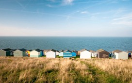Colourful beach huts facing the calm Atlantic sea at Whitstable, Kent