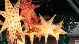 Festive lighting hangs from a Christmas market stall.