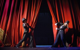 Performers opening the red curtains.