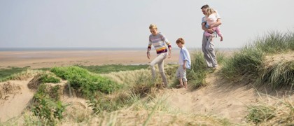 A family walking along the dunes at Presthaven