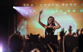 A DJ on stage at a Haven holiday park, with a crowd of holidaymakers on the dancefloor.