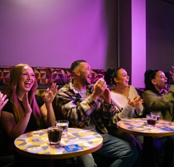 A group of grown-up holidaymakers enjoy the entertainment in a Haven venue.