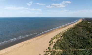A girl jumps on the sandy beach in her wellies near Haven Golden Sands, Mablethorpe.