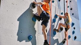Helmet and ropes at the ready before you take to the climbing wall