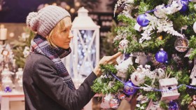 A woman admires a Christmas tree at a Christmas market.