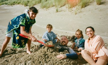 A family play together on the beach at Haven's Greenacres Holiday Park, North Wales.