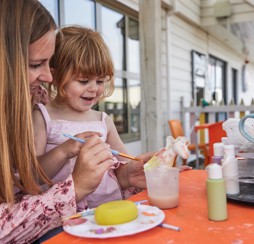 A young girl paints a unicorn.