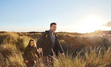 Couple walking in the dunes opposite Golden Sands