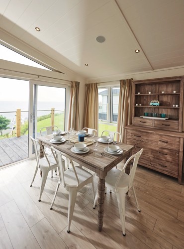 Representation of a dining area and a kitchen in a Signature Lake view lodge